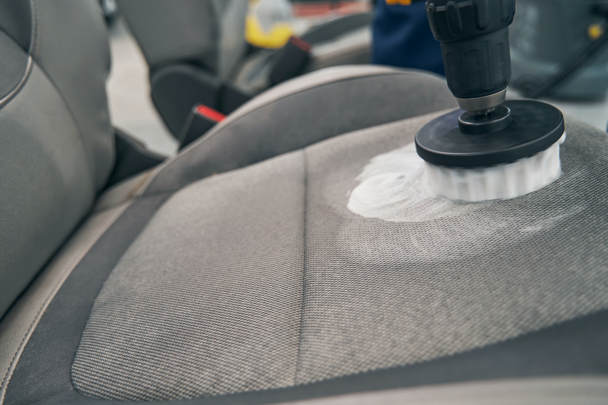 Closeup dry cleaning of car seat fabric with high-pressure cleaner